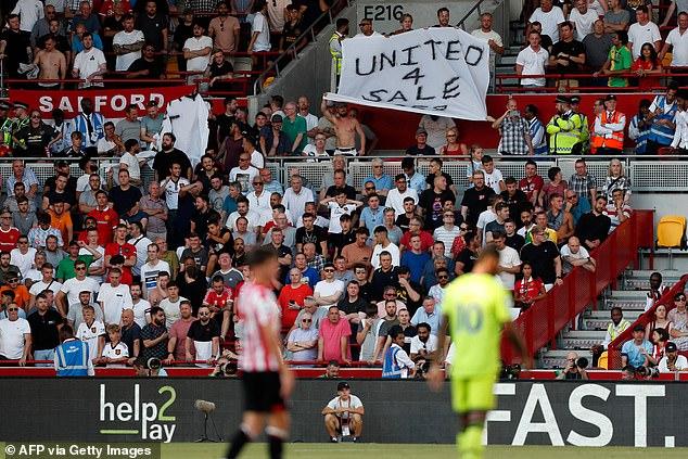 United fans raise a banner listing the club as 'for sale' during their 4-0 defeat at Brentford